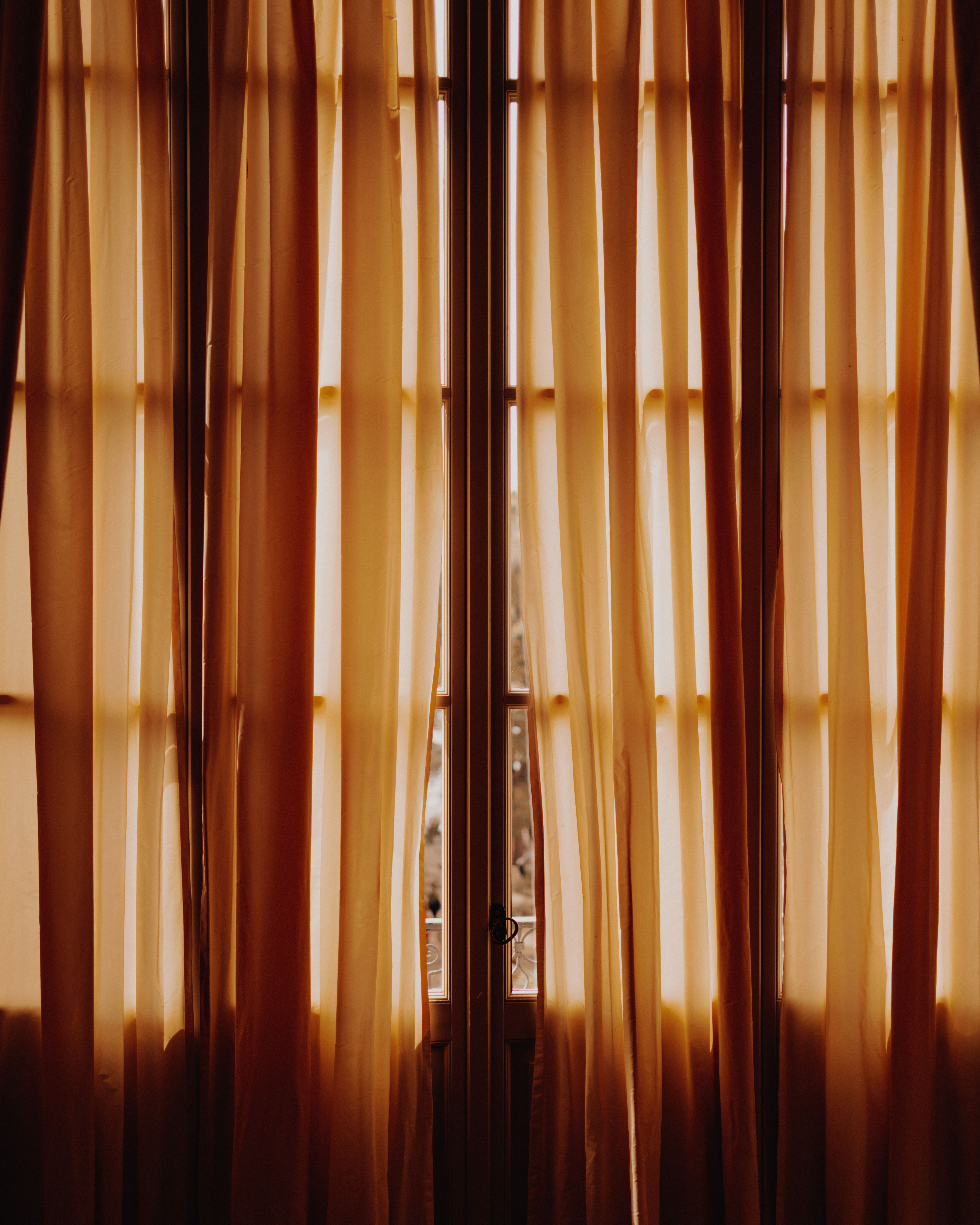 Warmes Sonnenlicht fällt durch ein leicht geöffnetes Fenster ins Zimmer.
